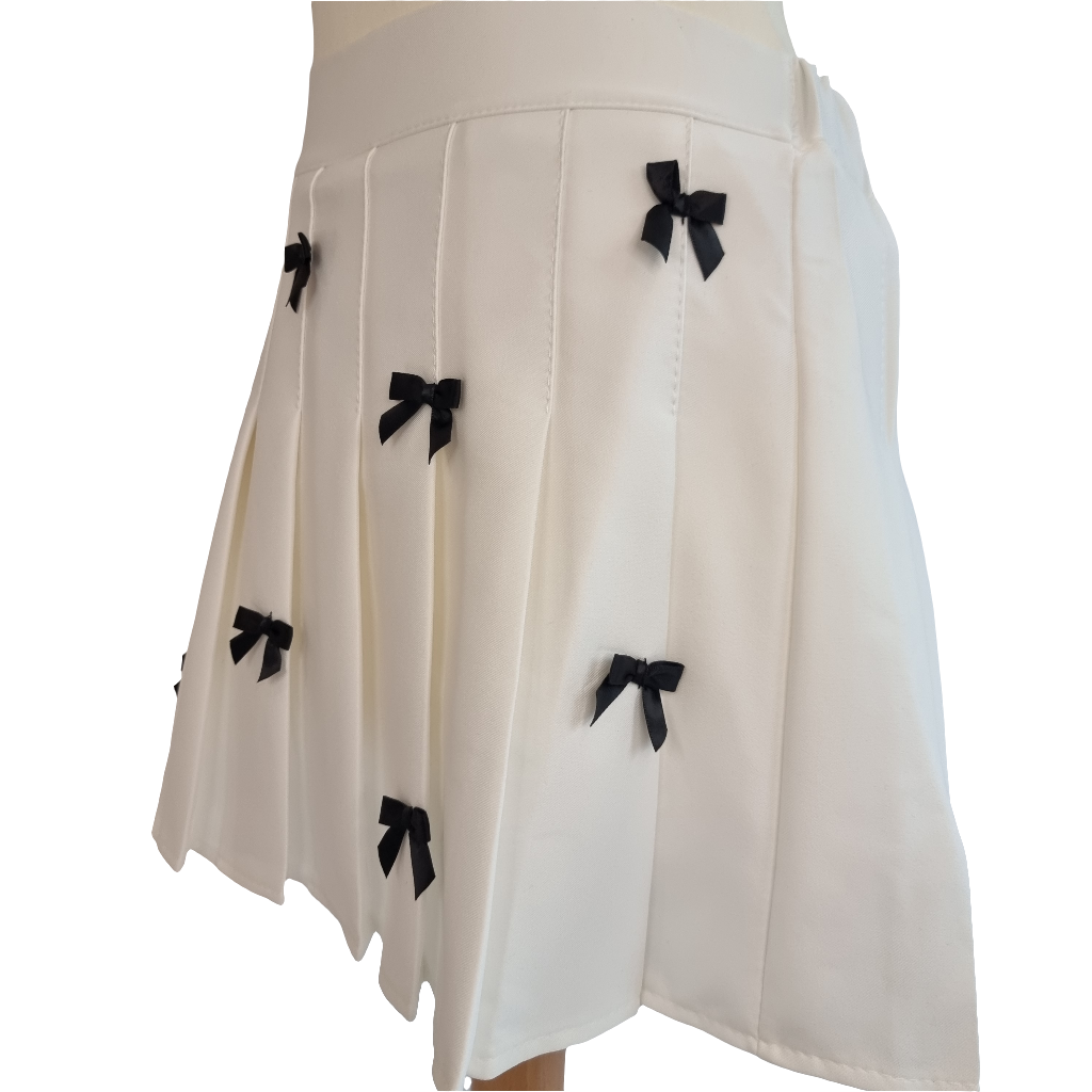 White Pleated Mini Skirt with Black Bow Embellishments