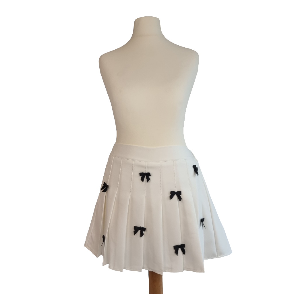 White Pleated Mini Skirt with Black Bow Embellishments